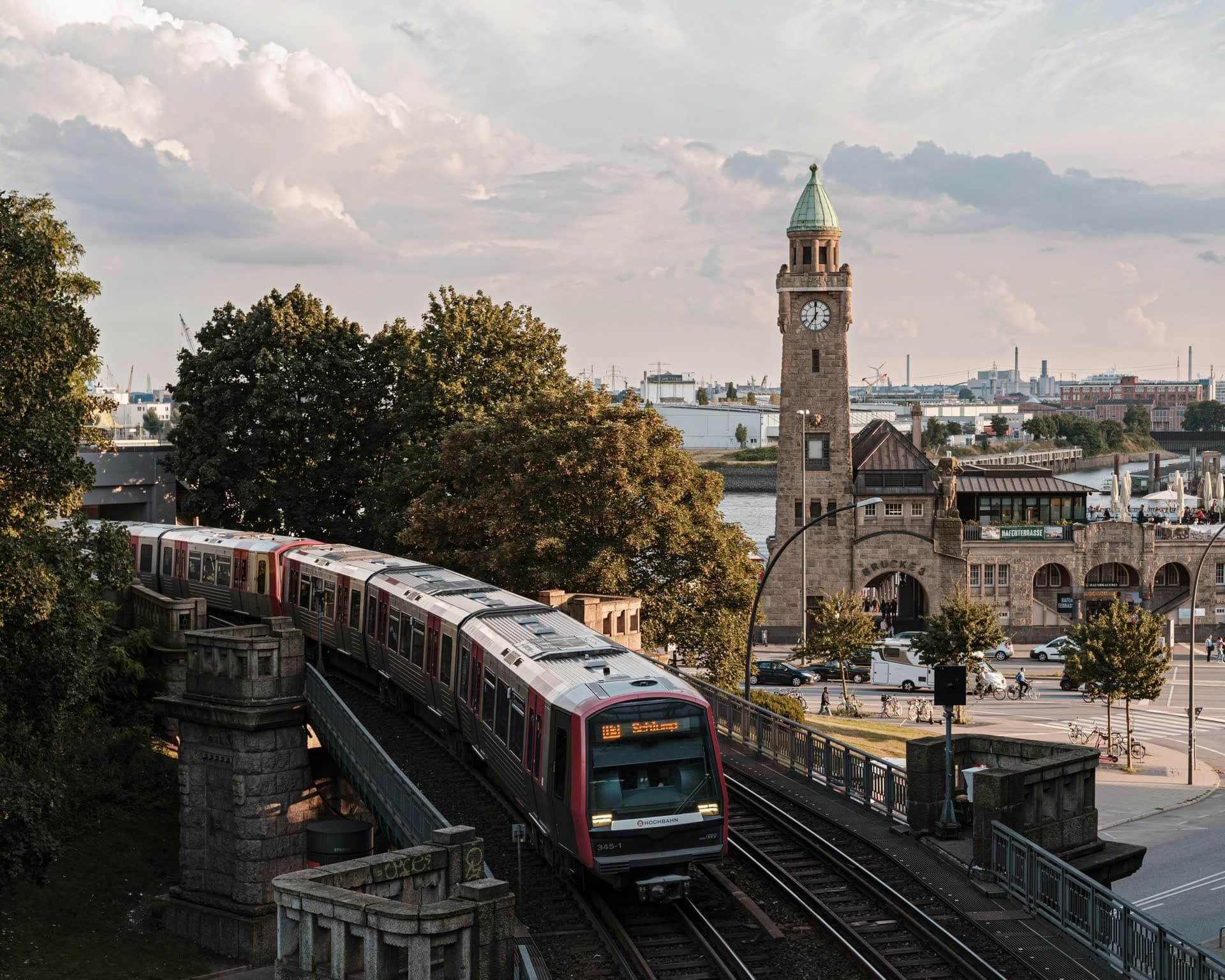 Train régional passant devant une tour-horloge en briques à Hambourg, en Allemagne