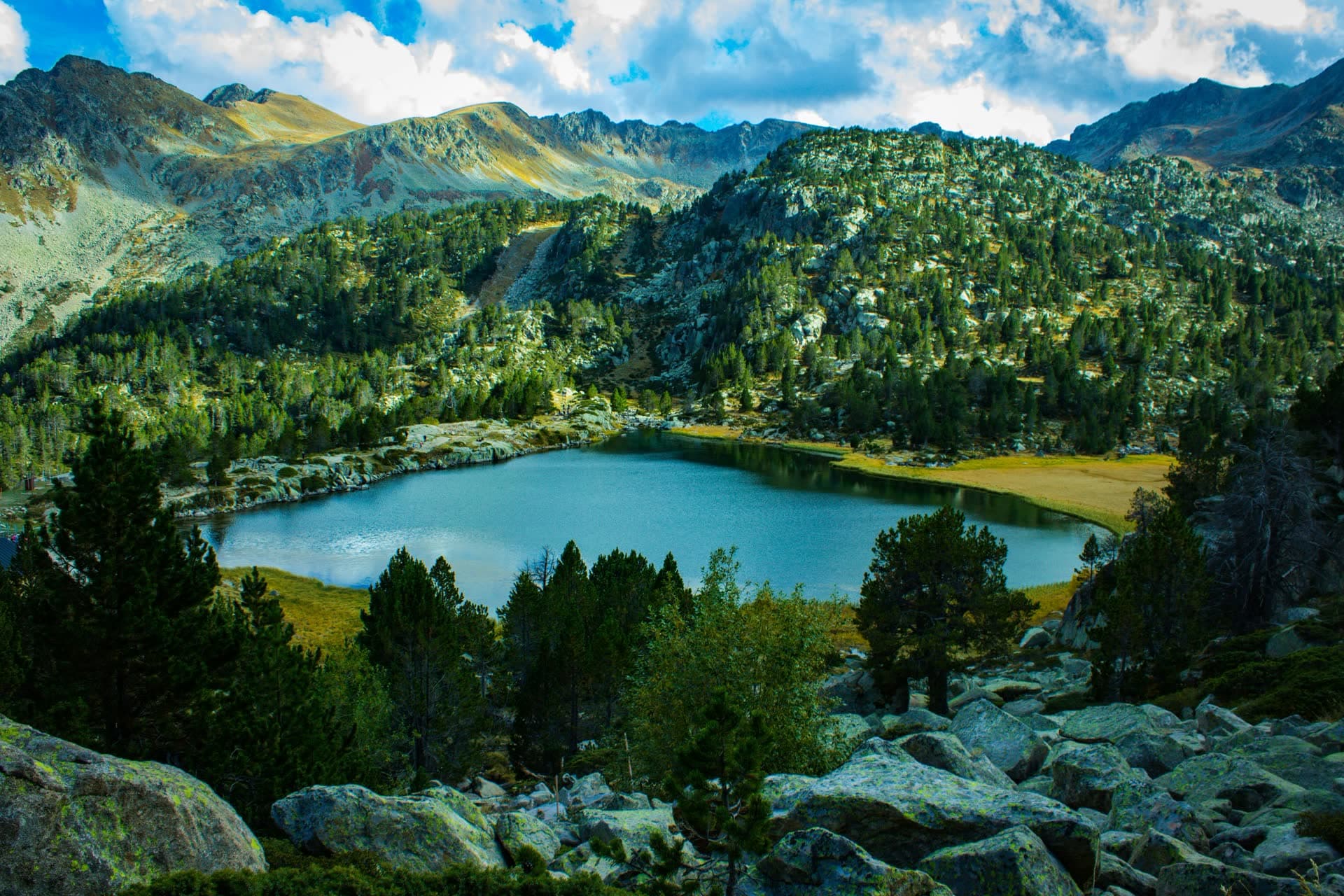 Lac de montagne entouré de forêts dans les Pyrénées andorranes. Vivre en Andorre : notre fiche expatriation.