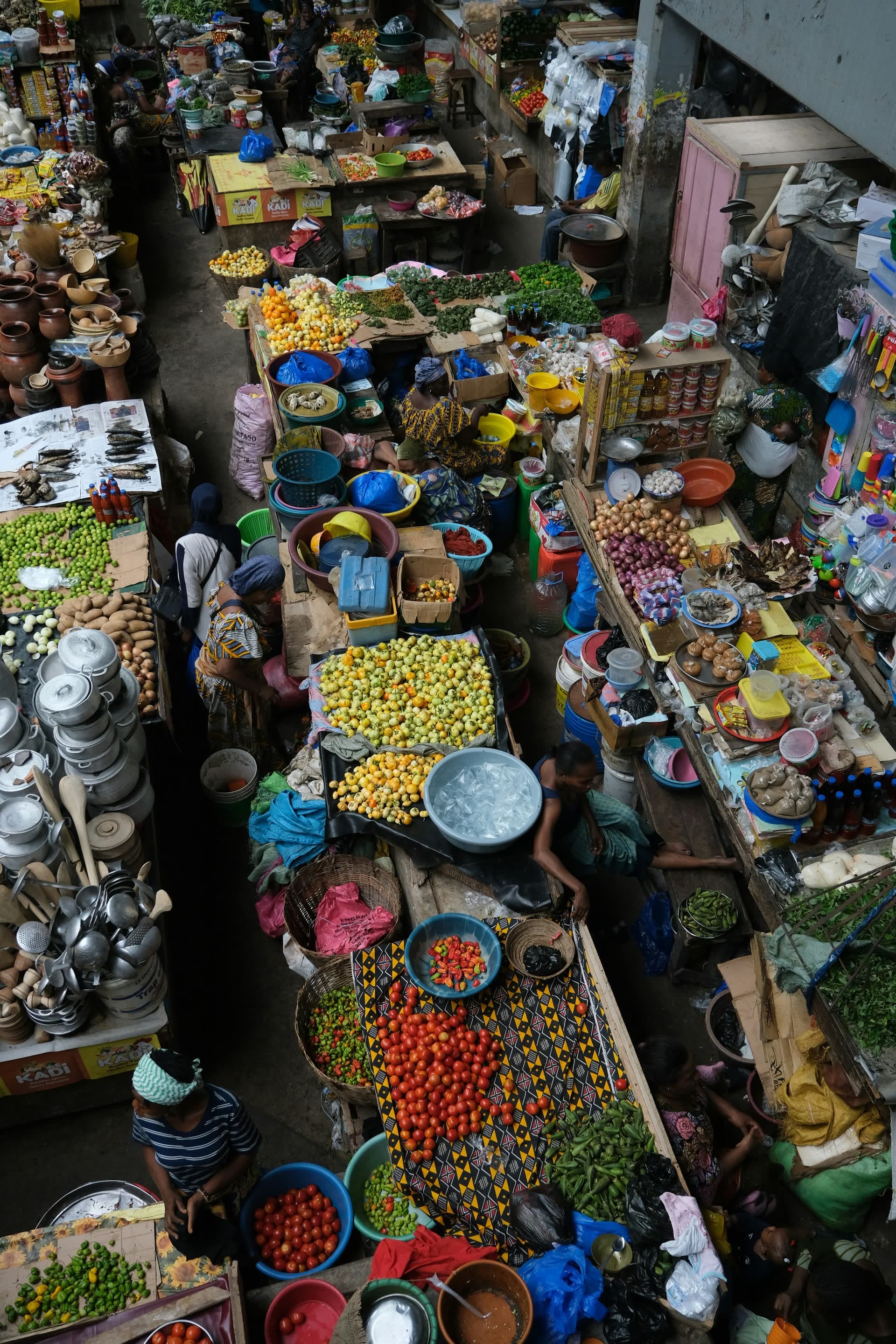 Marché populaire vu d'en haut, étals de fruits et de bassines, en Côte d'Ivoire. Vivre en Côte d'Ivoire : notre fiche expatriation.