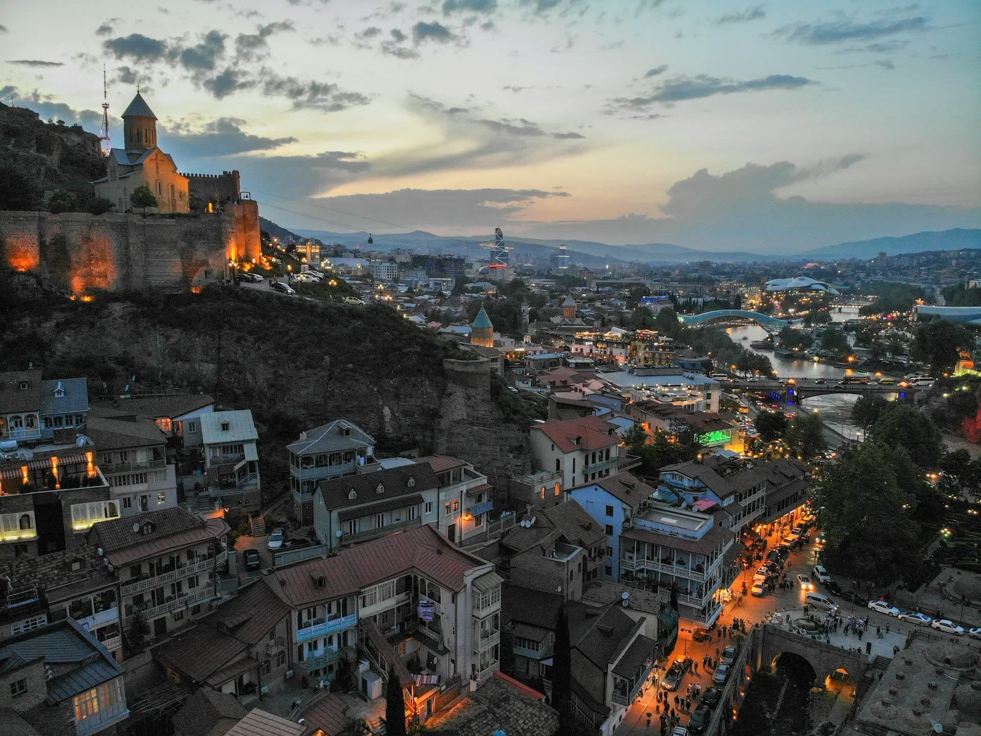 Tbilissi au crépuscule vue depuis les hauteurs, en Géorgie. Vivre en Géorgie : notre fiche expatriation.
