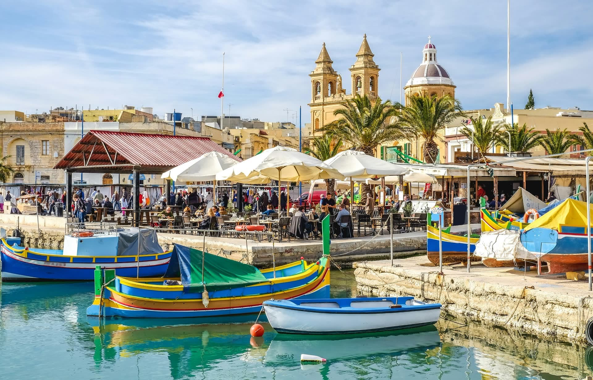 Barques de pêche luzzu colorées dans le port de Marsaxlokk, à Malte