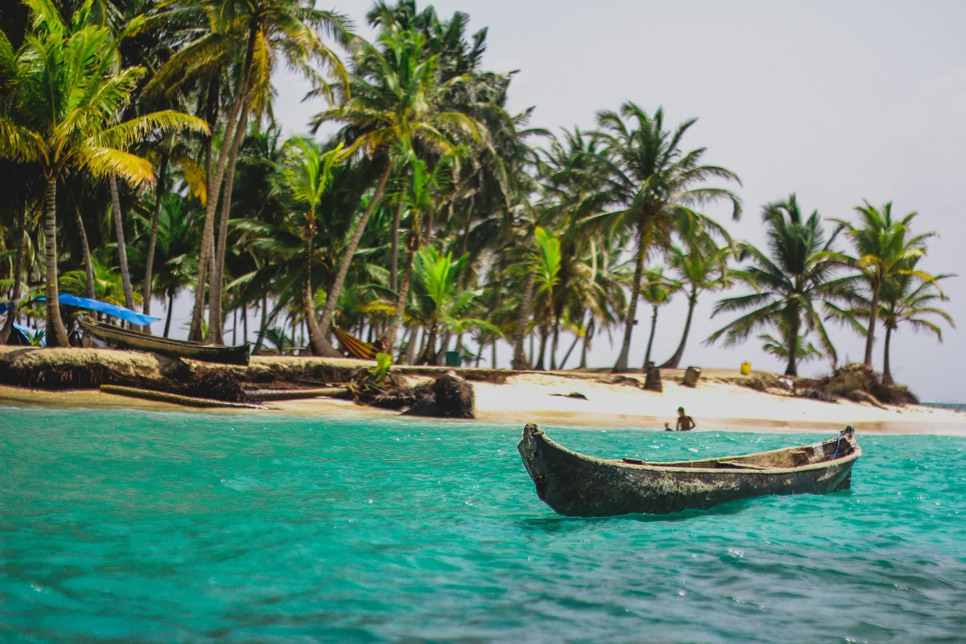 Pirogue sur une eau turquoise bordée de cocotiers, au Panama