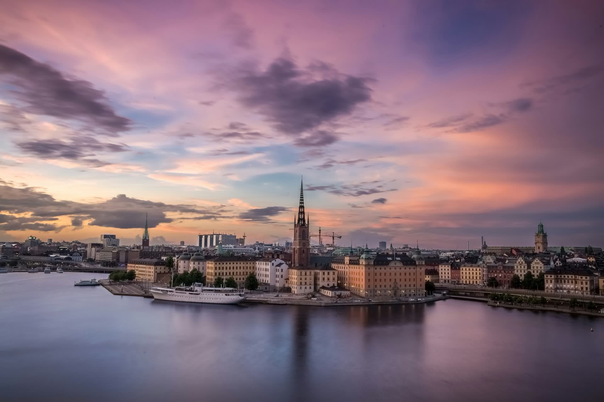 Stockholm au coucher du soleil et les clochers de Riddarholmen, en Suède. Vivre en Suède : notre fiche expatriation.